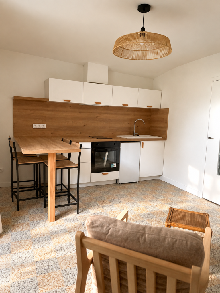 Cuisine de studio rénové près de Bergerac avec façades Toscane et plan de travail chêne boréal. Poignées bois